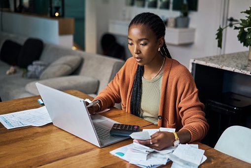 Woman budgeting at home on her laptop.