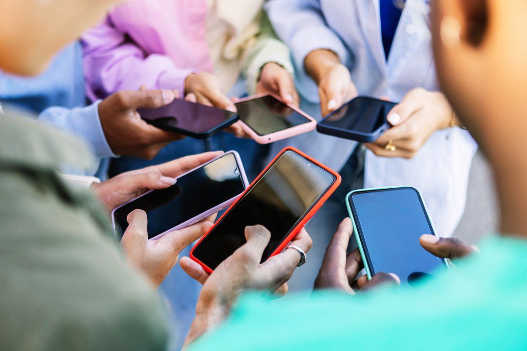 A people stood in a circle on their phones.