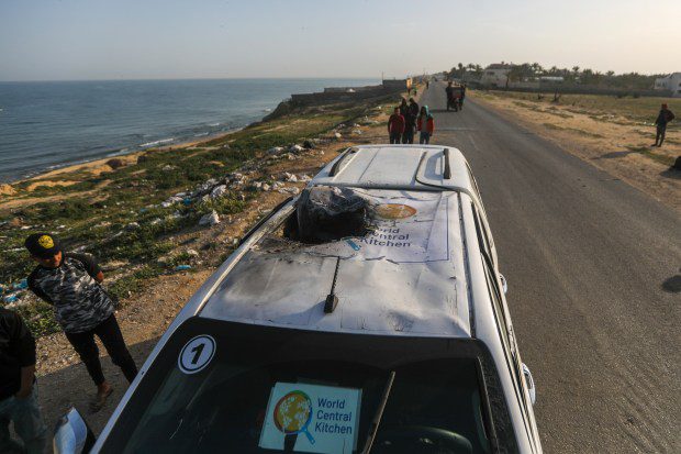 Palestinians inspect a vehicle with the logo of the World Central Kitchen wrecked by an Israeli airstrike in Deir al Balah, Gaza Strip, Tuesday, April 2, 2024. A series of airstrikes killed seven aid workers from the international charity, leading it to suspend delivery Tuesday of vital food aid to Gaza. (AP Photo/Ismael Abu Dayyah)