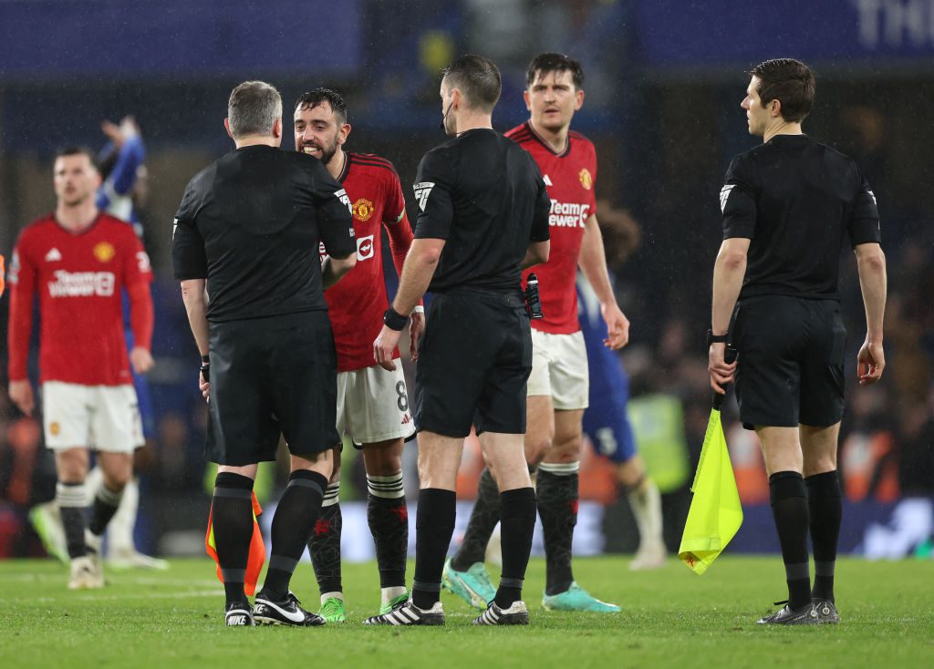 Manchester United players surround the referee